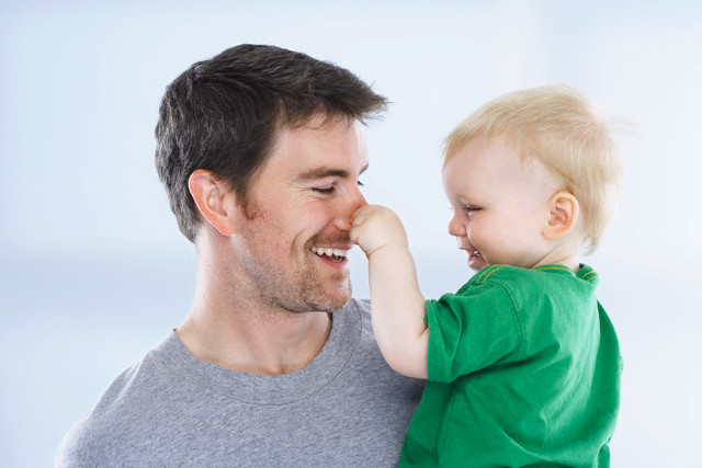 Son Pulling Father's Nose --- Image by © Radius Images/Corbis